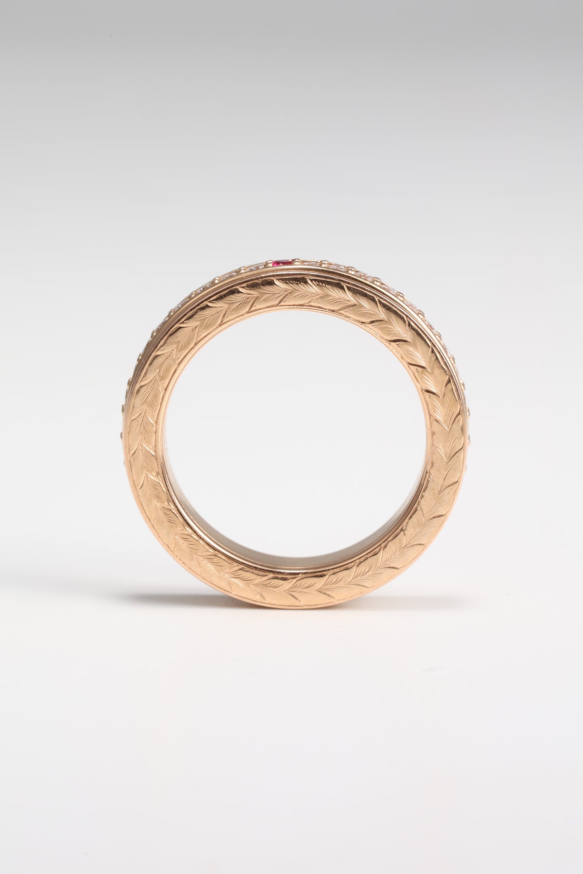 Hand-engraved leaf pattern on the side of the handmade rose gold spinner ring
