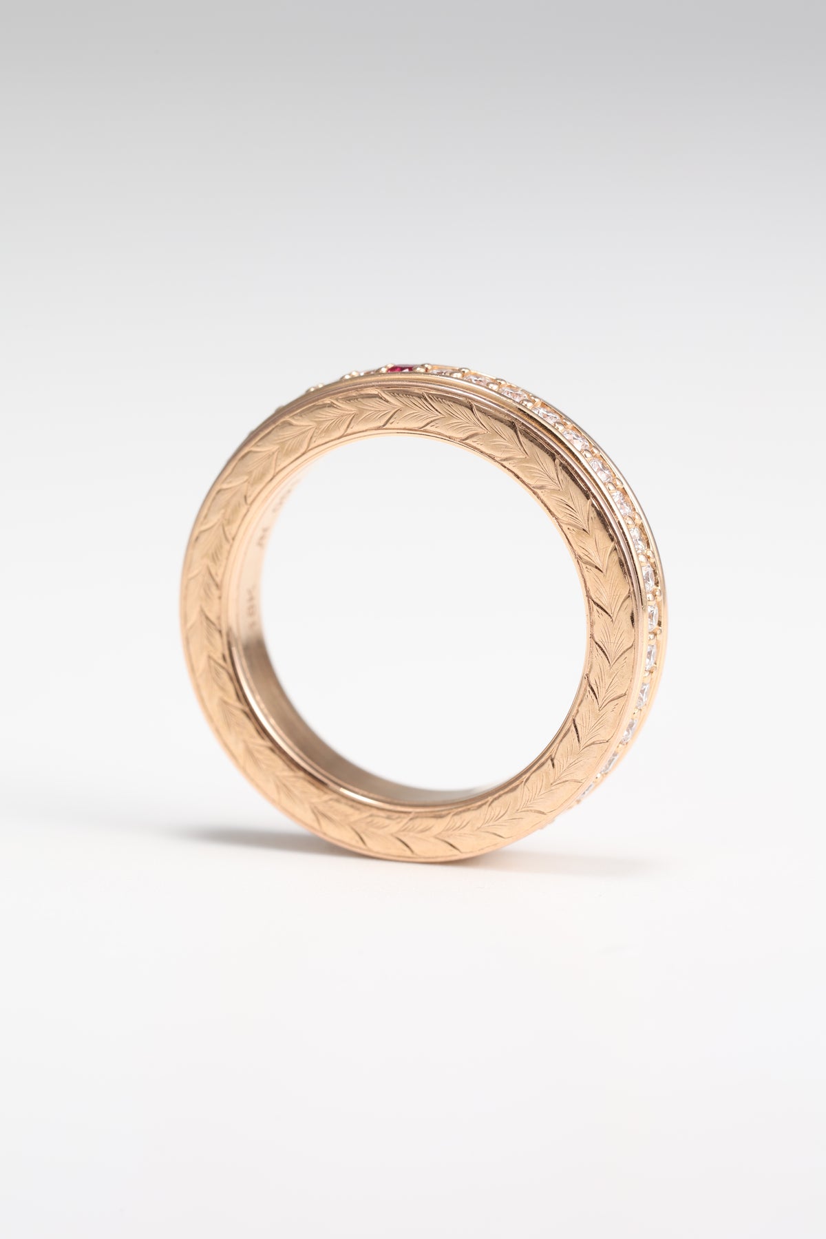 Rose gold spinner ring showing engraved side and diamond-set rotating band